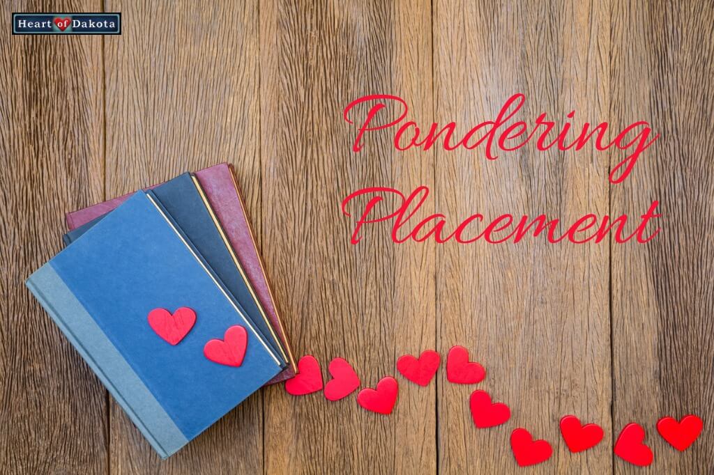 3 small notebooks lying on a wooden table with a trail of small red hearts leading to them.